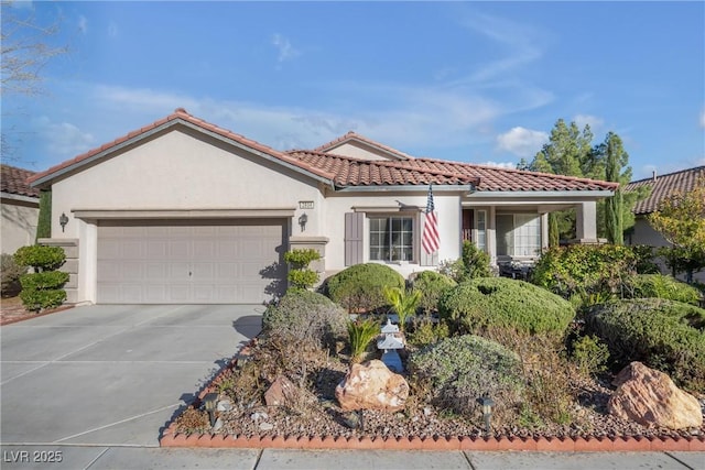 mediterranean / spanish home featuring a tile roof, driveway, an attached garage, and stucco siding