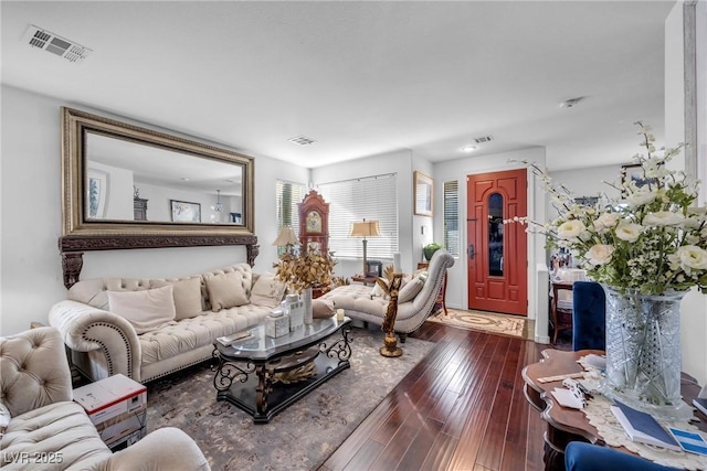 living room with dark wood-style flooring and visible vents