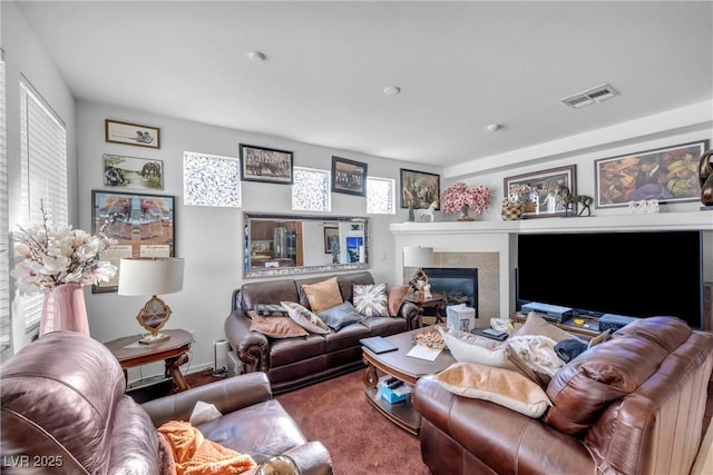 living room with carpet flooring, a tile fireplace, and visible vents