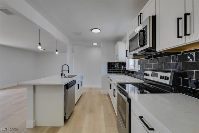 kitchen featuring tasteful backsplash, visible vents, appliances with stainless steel finishes, light wood-style floors, and a sink