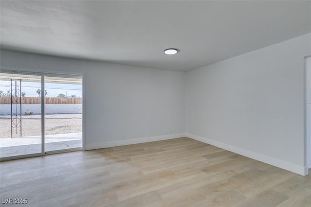unfurnished room with light wood finished floors and baseboards
