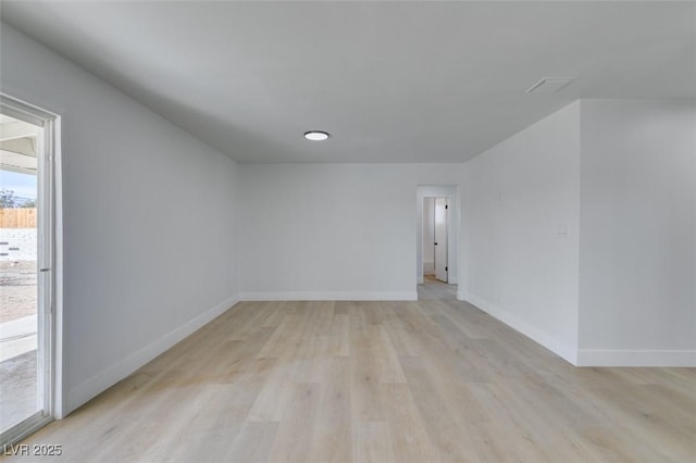 empty room with light wood finished floors and baseboards
