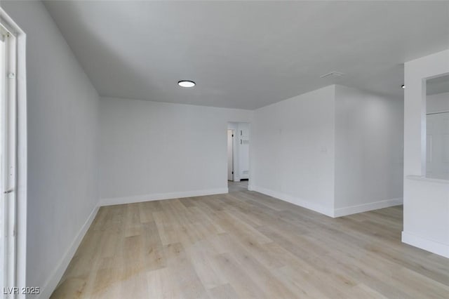 unfurnished room with light wood-style flooring and baseboards
