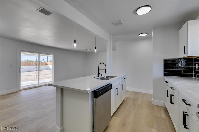 kitchen featuring a sink, visible vents, stainless steel dishwasher, light wood finished floors, and tasteful backsplash