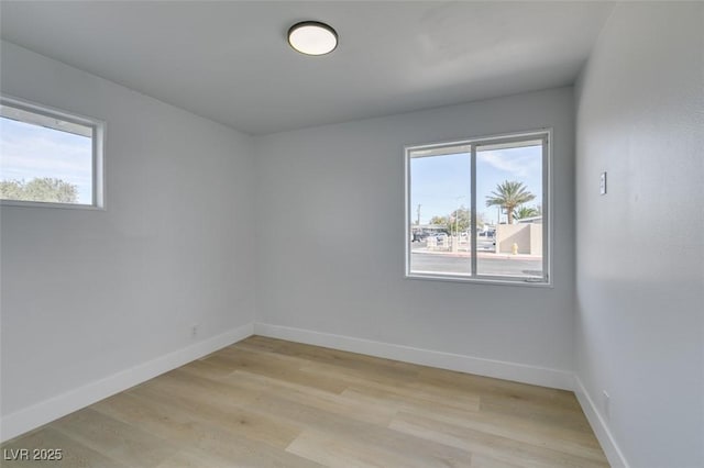 empty room with light wood-style flooring and baseboards
