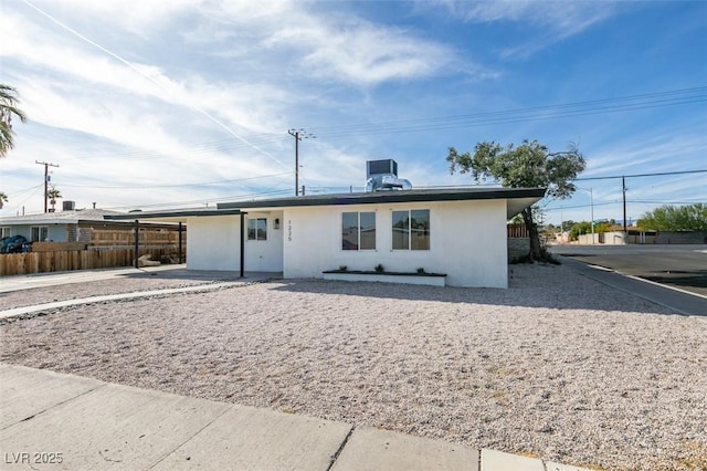 ranch-style home with fence and stucco siding