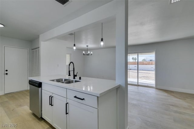 kitchen with light wood-style flooring, a sink, white cabinets, light countertops, and stainless steel dishwasher