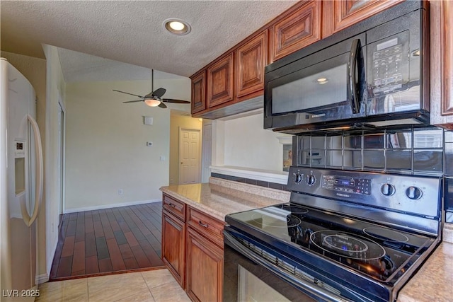 kitchen with black appliances, light countertops, and brown cabinetry