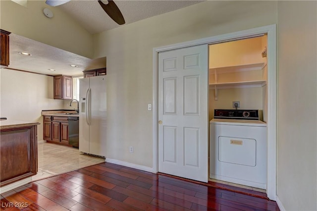 washroom with washer / dryer, light wood-style flooring, laundry area, and a textured ceiling