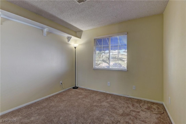 empty room with carpet floors, baseboards, and a textured ceiling