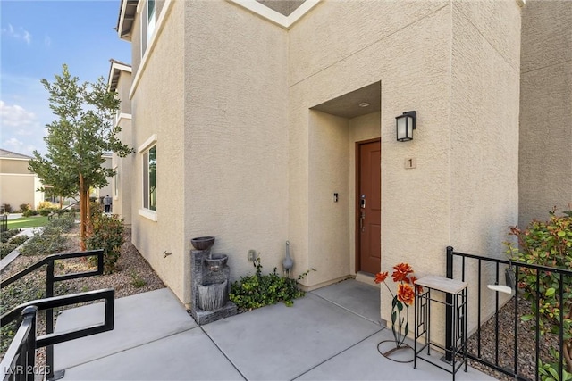 doorway to property with a patio and stucco siding