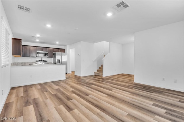 unfurnished living room featuring stairs, light wood-type flooring, visible vents, and recessed lighting