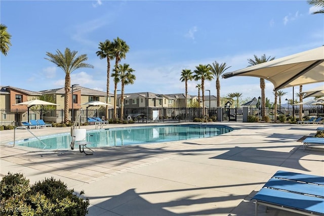 community pool featuring a residential view, a patio area, and fence