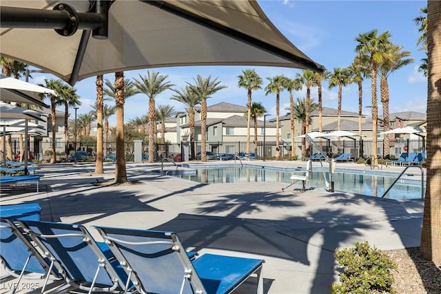 community pool featuring a patio area, a residential view, and fence