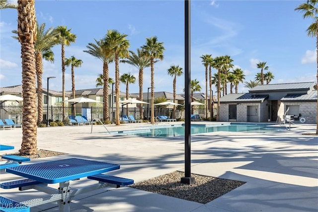 community pool featuring a residential view, a patio, and fence