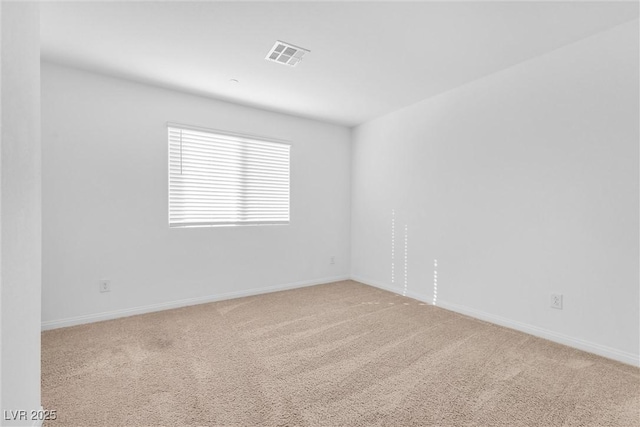 carpeted spare room with visible vents and baseboards