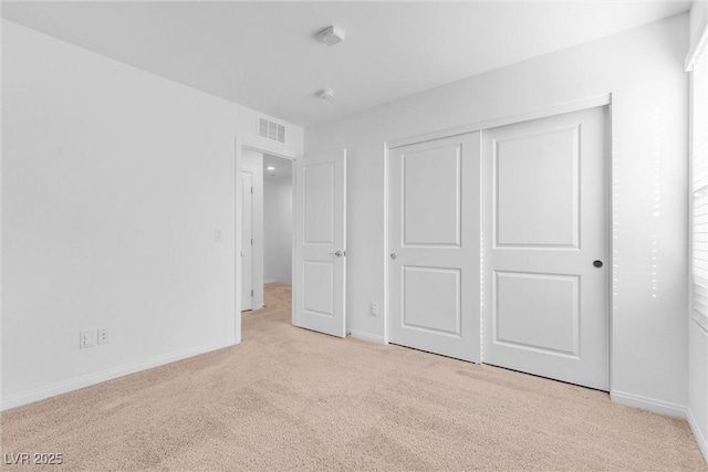 unfurnished bedroom featuring carpet floors, baseboards, visible vents, and a closet