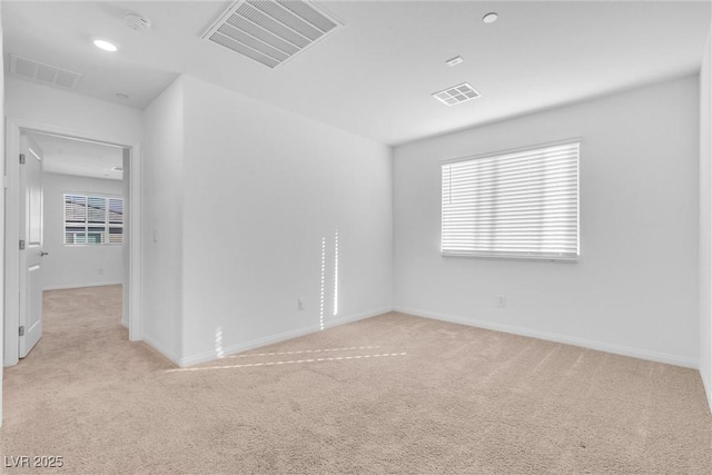 unfurnished room with light carpet, visible vents, and baseboards