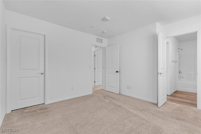 unfurnished bedroom with carpet flooring, visible vents, and baseboards