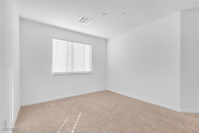 spare room with carpet floors, baseboards, and visible vents