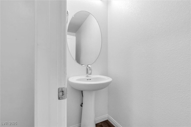 bathroom with baseboards and wood finished floors