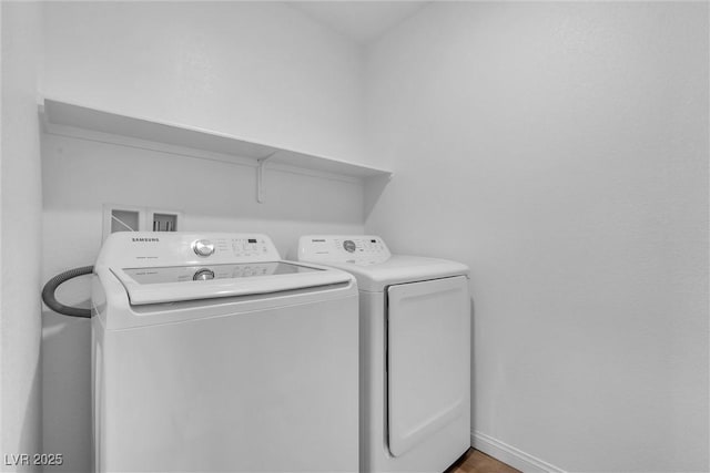 laundry area with laundry area, washing machine and clothes dryer, and baseboards