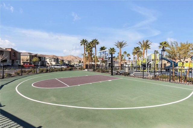 view of basketball court with community basketball court, a residential view, playground community, and fence