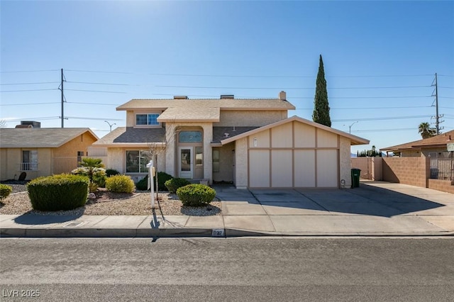 view of front of home featuring a garage, concrete driveway, fence, and stucco siding