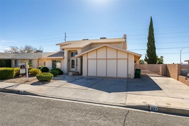 view of front of home featuring a garage, fence, concrete driveway, a gate, and stucco siding