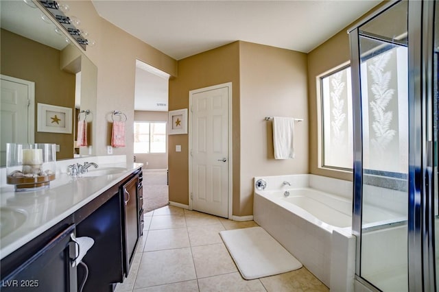 bathroom with a garden tub, a shower with door, double vanity, a sink, and tile patterned floors