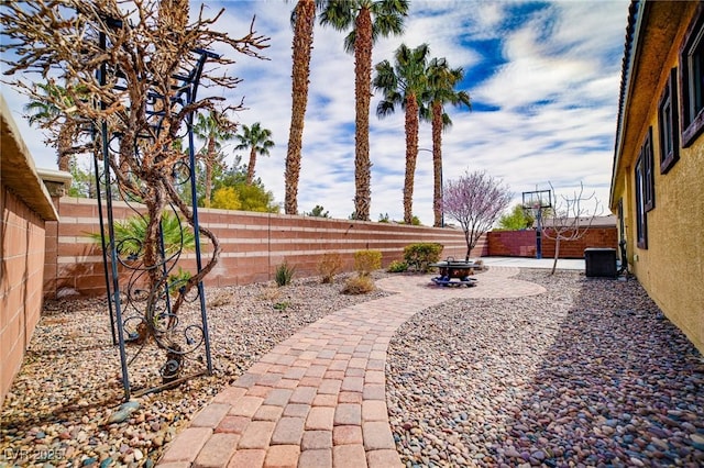 view of yard featuring a fenced backyard, a patio, and central AC