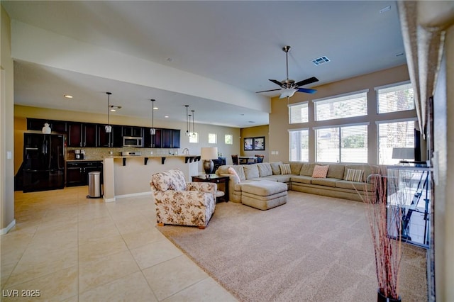 living area featuring light tile patterned floors, recessed lighting, visible vents, baseboards, and a ceiling fan