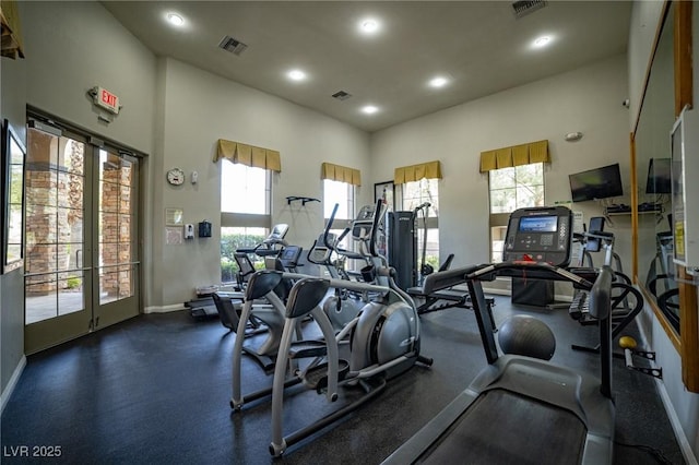 workout area featuring a high ceiling, visible vents, and baseboards