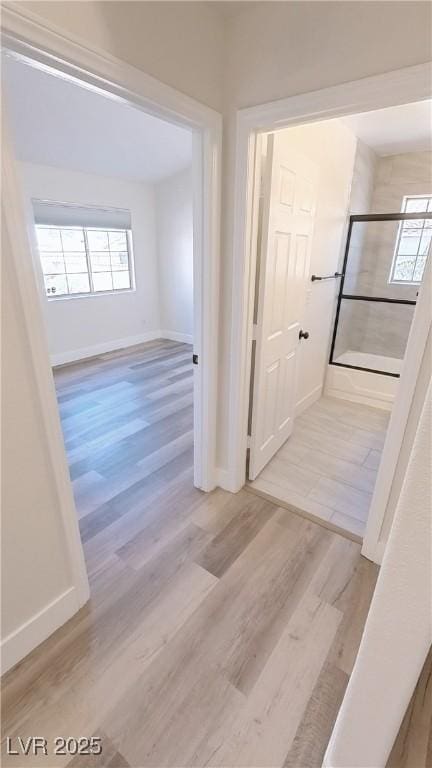 hall featuring baseboards and wood finished floors