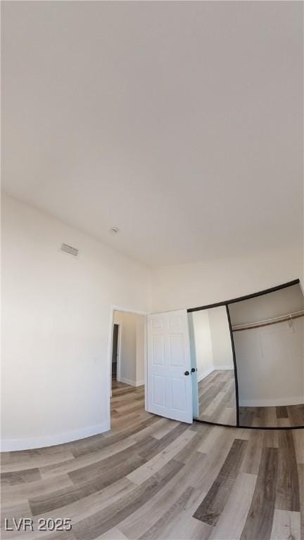 unfurnished bedroom with light wood-type flooring and baseboards