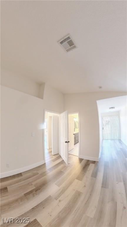 unfurnished room with light wood-style floors, baseboards, and visible vents