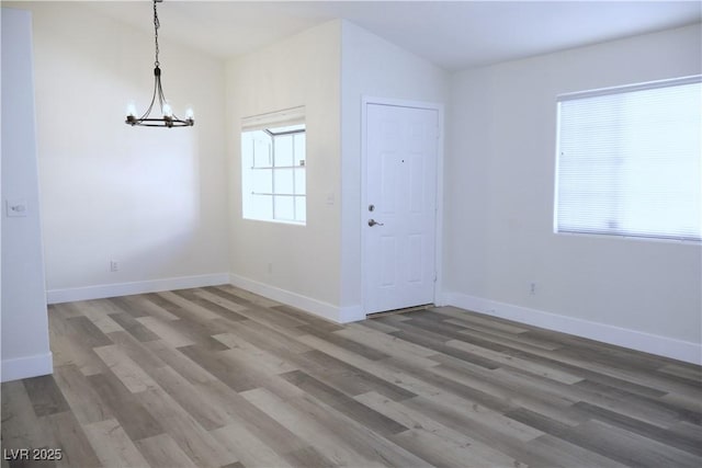 1624 N Torrey Pines Dr Unit 101, Las Vegas, NV 89108 - unfurnished dining area with a chandelier, wood finished floors, and baseboards