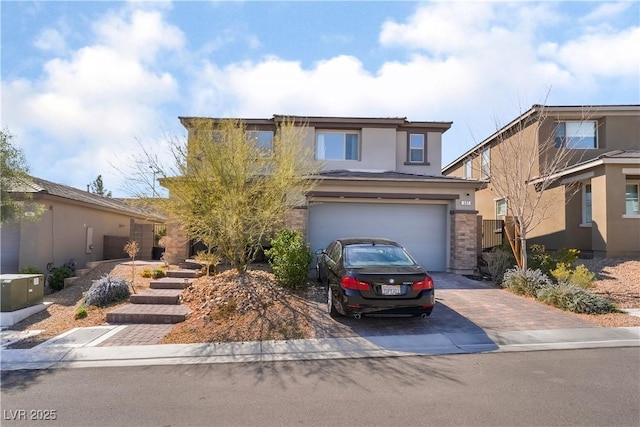 traditional-style home featuring decorative driveway, a garage, and stucco siding