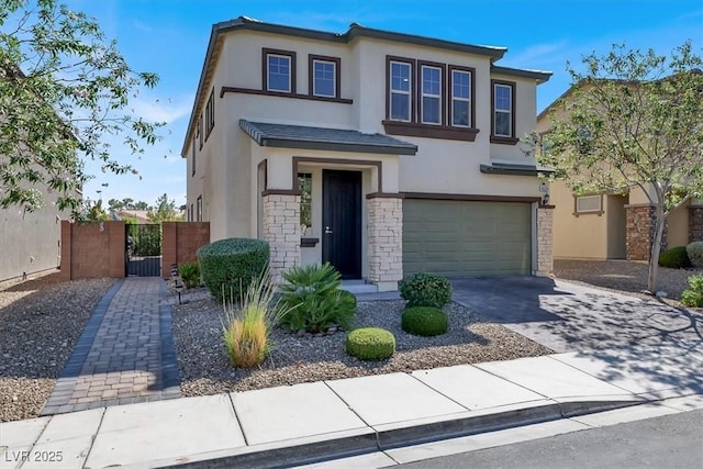 view of front of property featuring concrete driveway, stone siding, an attached garage, a gate, and stucco siding