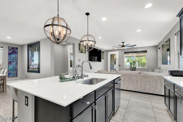 kitchen featuring recessed lighting, a sink, light countertops, stainless steel dishwasher, and decorative light fixtures