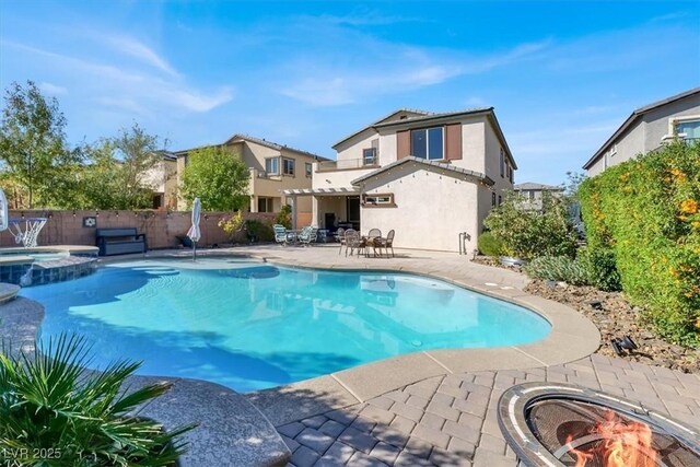 view of swimming pool with a fire pit, a patio area, a fenced backyard, and a pool with connected hot tub