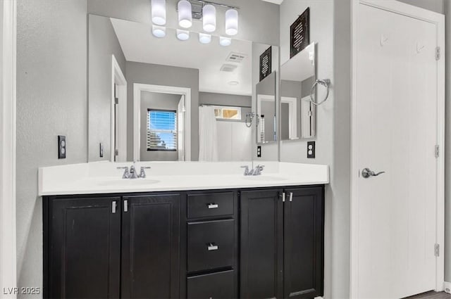 full bathroom featuring a sink and double vanity