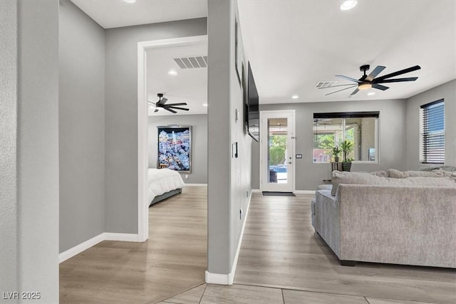 living room featuring light wood-style floors, baseboards, and visible vents