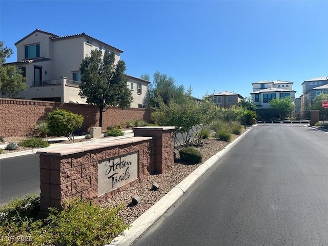 view of street featuring traffic signs, a gated entry, and curbs