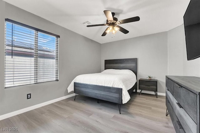 bedroom featuring light wood-type flooring, baseboards, visible vents, and a ceiling fan