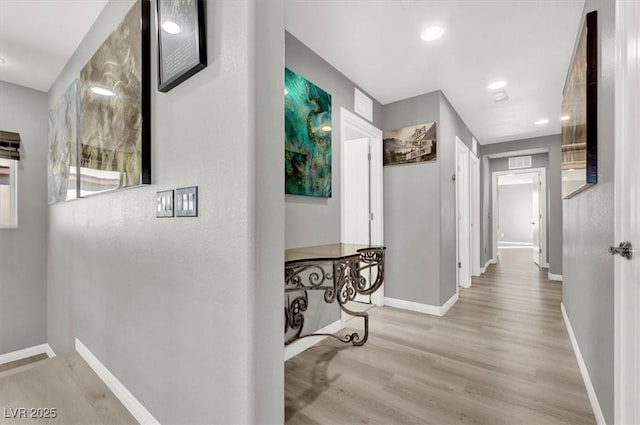 hall featuring recessed lighting, visible vents, baseboards, and wood finished floors