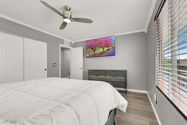 bedroom featuring baseboards, a ceiling fan, ornamental molding, wood finished floors, and a closet