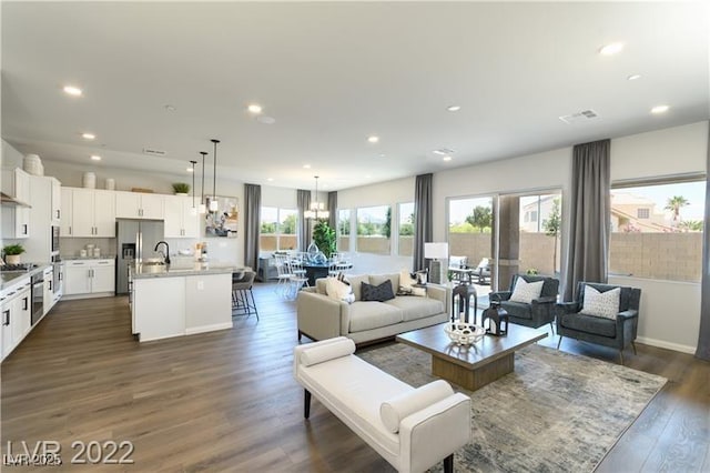 6324 Zephyr Ct, Las Vegas, NV 89149 - living room with recessed lighting, visible vents, a chandelier, and dark wood finished floors