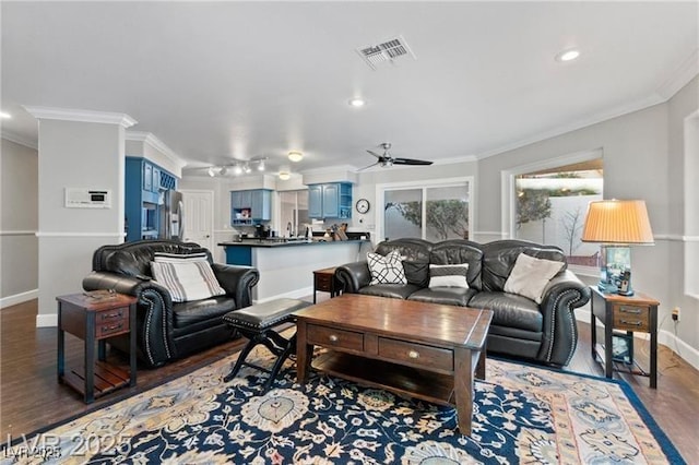 living area featuring baseboards, visible vents, a ceiling fan, ornamental molding, and wood finished floors