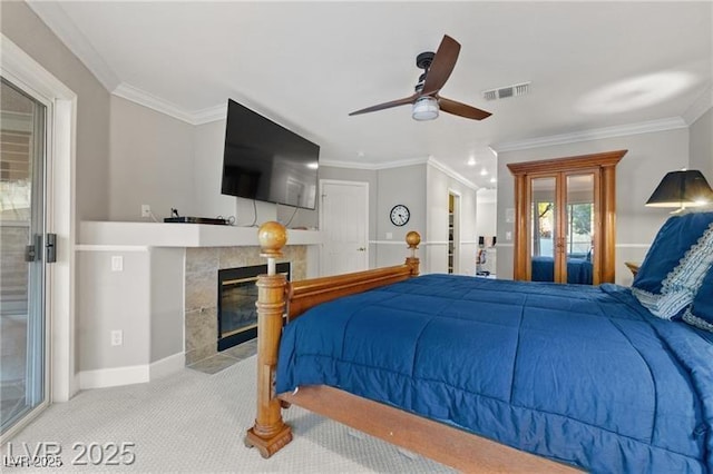 carpeted bedroom with crown molding, a fireplace, visible vents, a ceiling fan, and baseboards